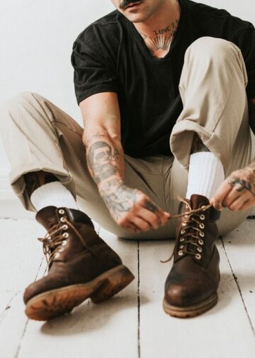 alternative-man-tying-boots-shoelaces-floor_53876-101248